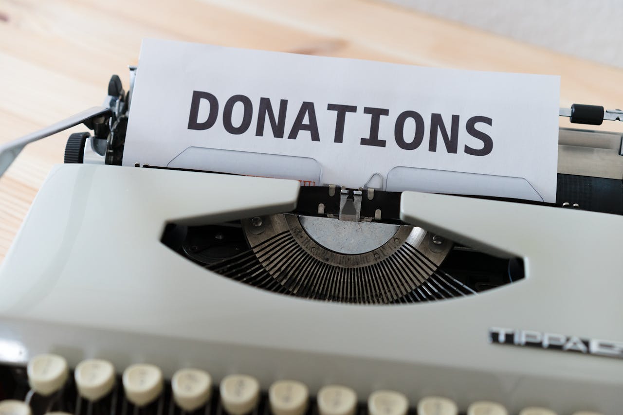 Close-up of a vintage typewriter with a paper displaying the word DONATIONS.